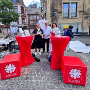 Die Kollegen präsentieren sich an roten Stehtischen mit Informationen auf dem Katschhof in AAchen.