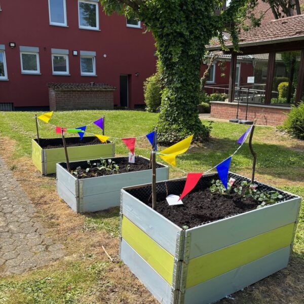 drei Hochbeete von moliri mit bunten Wimpelketten verziert