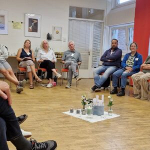Die Teilnehmenden sitzen im Stuhlkreis und verfolgen das Seminar.