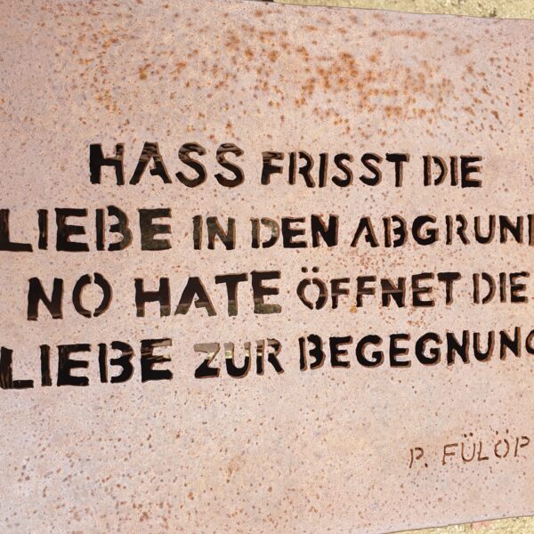 In das Kunstwerk ist folgender Satz gefräst: Hass frisst die Liebe in den Abgrund. No Hate öffnet die Liebe zur Begegnung.