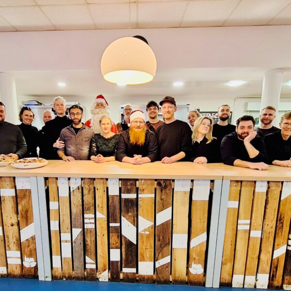 Die Mitarbeitendes des Café Plattform steht gesammelt hinter einer weihnachtlich geschmückten Holztheke.