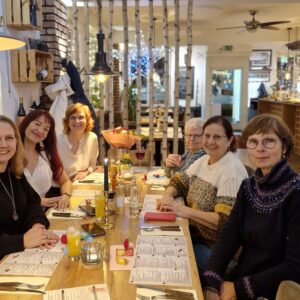 Die Familienpatinnen sitzen gemeinsam um den Tisch und feiern das Neujahrstreffen.