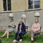 Die ehrenamtlichen älteren Menschen schauen sich die Ausstellung "Alltagsmenschen" an.