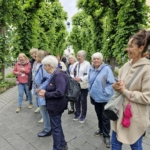 Die ehrenamtlichen älteren Menschen hören gespannt bei der Führung zur Ausstellung "Alltagsmenschen" zu.