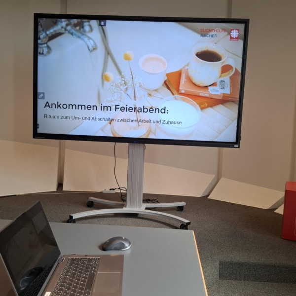 Laptop und Smart-TV, auf das der Vortrag projiziert wird