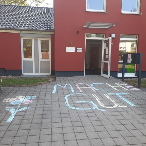 Vor dem Gebäude steht mit Kreise gemalt auf dem Boden: Mach's gut!