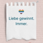 Abreißzettel mit Herz in Regenbogenfarben, darunter der Satz Liebe gewinnt. Immer.